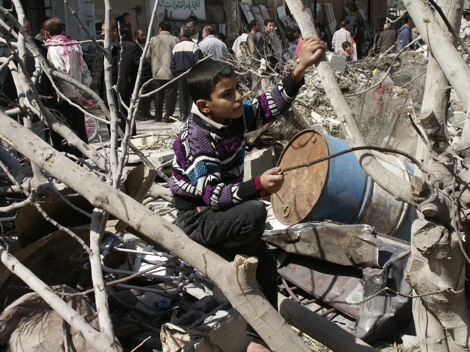 Ein Sohn spielt gedankenverloren auf den Trümmern