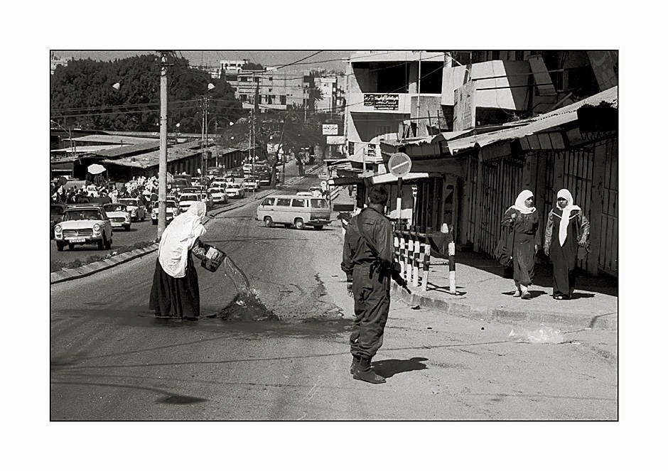1989 - ein Soldat zwingt eine Frau, einen brennende Reifen zu löschen