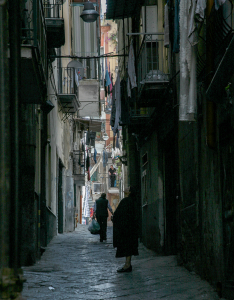 Mehrstöckige, große Häuser hüllen die Gassen in Dunkelheit