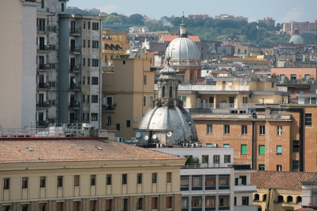 Ansicht über die Dächer der Altstadt von Neapel. Bei der großen Kuppel im Vordergrund handelt es sich wahrscheinlich um die Kuppel der Basilika dello Spirito Santo (Heilig-Geist-Basilika). Standort: Die Basilika befindet sich in der Via Toledo, einer wichtigen Einkaufsstraße im Zentrum von Neapel.Architektur: Die Kirche ist ein bedeutendes Beispiel der Renaissance-Architektur in der Stadt. Die Kuppel, die im Bild zu sehen ist, dominiert die umliegenden Gebäude.Aussicht: Solche Ausblicke über die "Stadt der 500 Kuppe