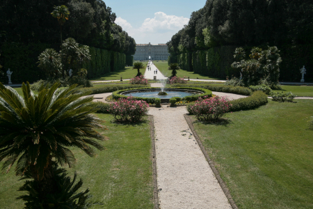 Königlicher Palast von Caserta (Reggia di Caserta), der sich in Caserta, etwa 40 Kilometer nördlich von Neapel, befindet. UNESCO-Weltkulturerbe: Der Palast und der weitläufige Garten gehören seit 1997 zum UNESCO-Weltkulturerbe und gelten als eines der größten Barockbauwerke Europas.Der Park: Die Anlage, inspiriert durch den Park von Versailles, erstreckt sich über 120 Hektar und verfügt über eine lange "Via d'Acqua" (Wasserstraße) mit zahlreichen kunstvollen Brunnen und Kaskaden, darunter die Fontana Margherita im Vordergrund.