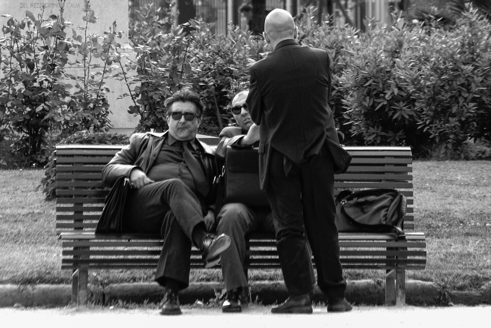 Drei Mafiosi bei einer Übergabe von Geld oder Dokumenten. Als sie bemerkten, dass ich sie im Park fotografierte, packten sie sofort ihre Sachen und suchten ein weniger lauschiges Plätzchen!